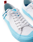 Pair of Dipped Kicks white shoes with blue soles