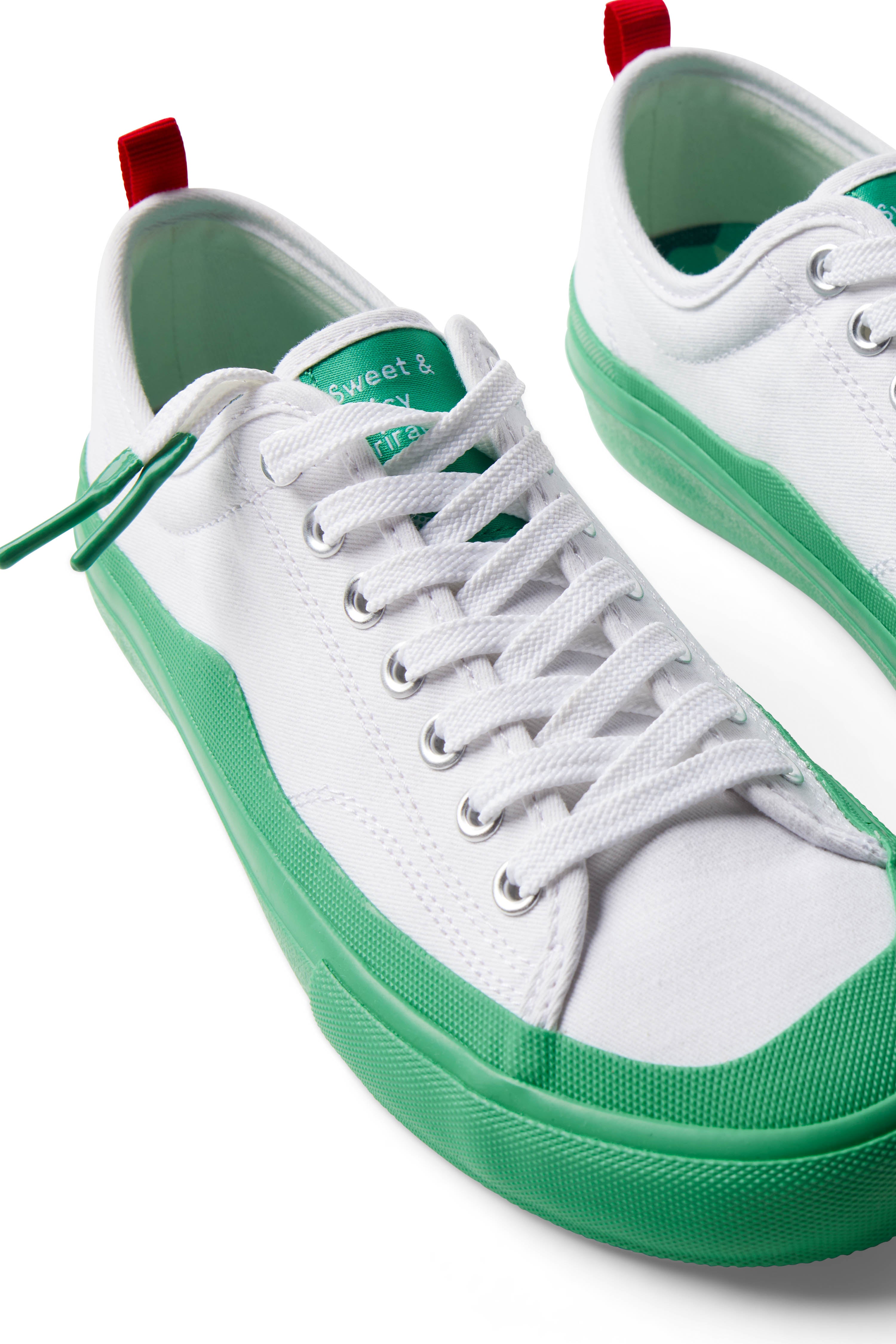 Pair of Dipped Kicks white shoes with green soles