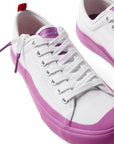 Pair of Dipped Kicks white shoes with purple soles