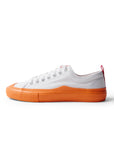 Side view of single Dipped Kicks white shoes with orange soles