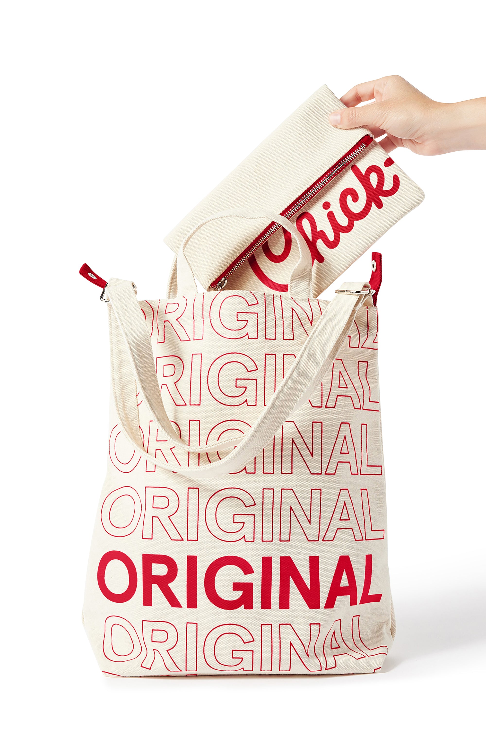 Person placing Classic Chick-fil-A™ Clutch into Chick-fil-A Original Bucket Tote