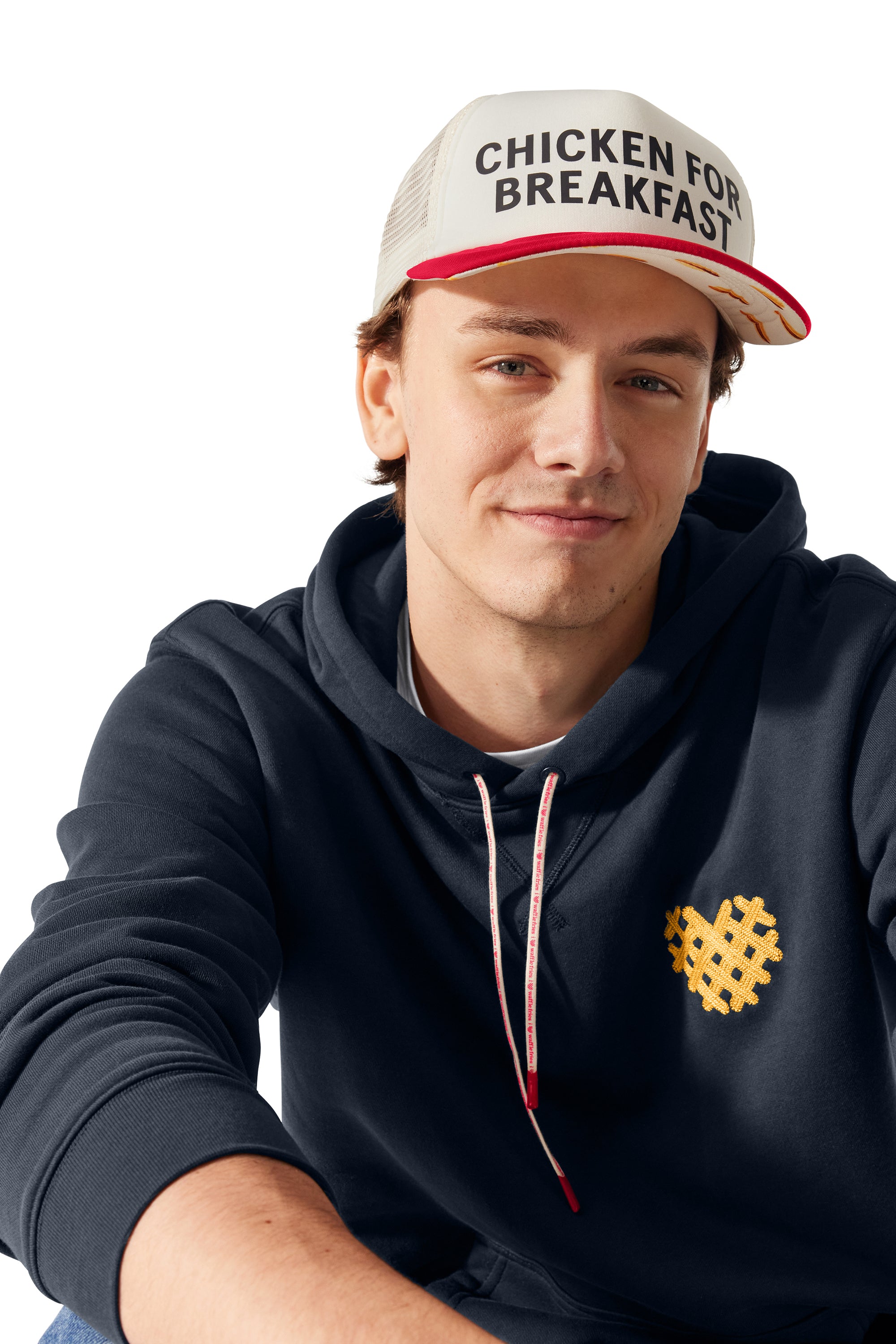 Man wearing I Heart Waffle Fries Hoodie and Chicken for Breakfast Trucker Hat