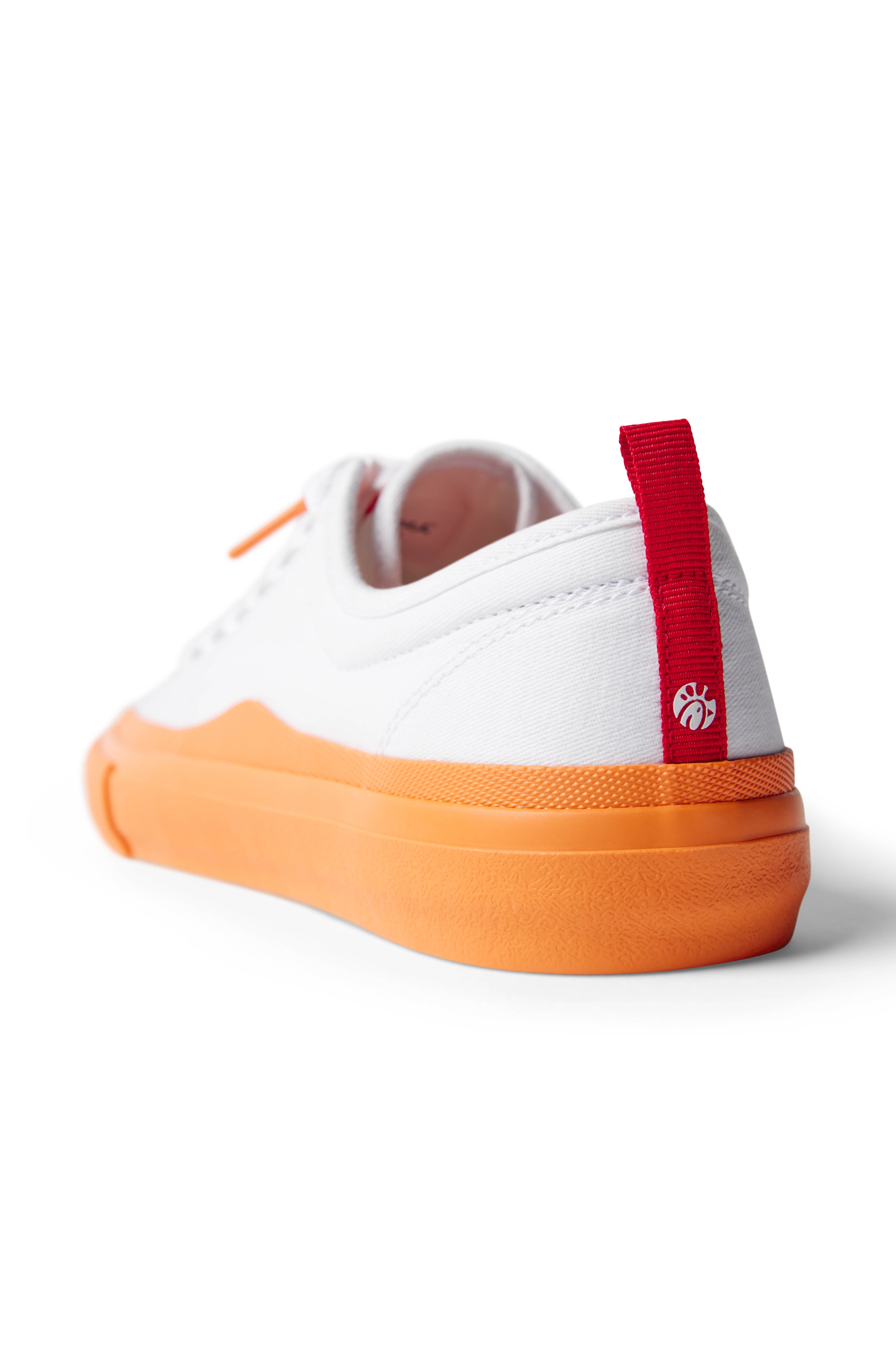 Back view of single Dipped Kicks white shoes with orange soles and red back tag