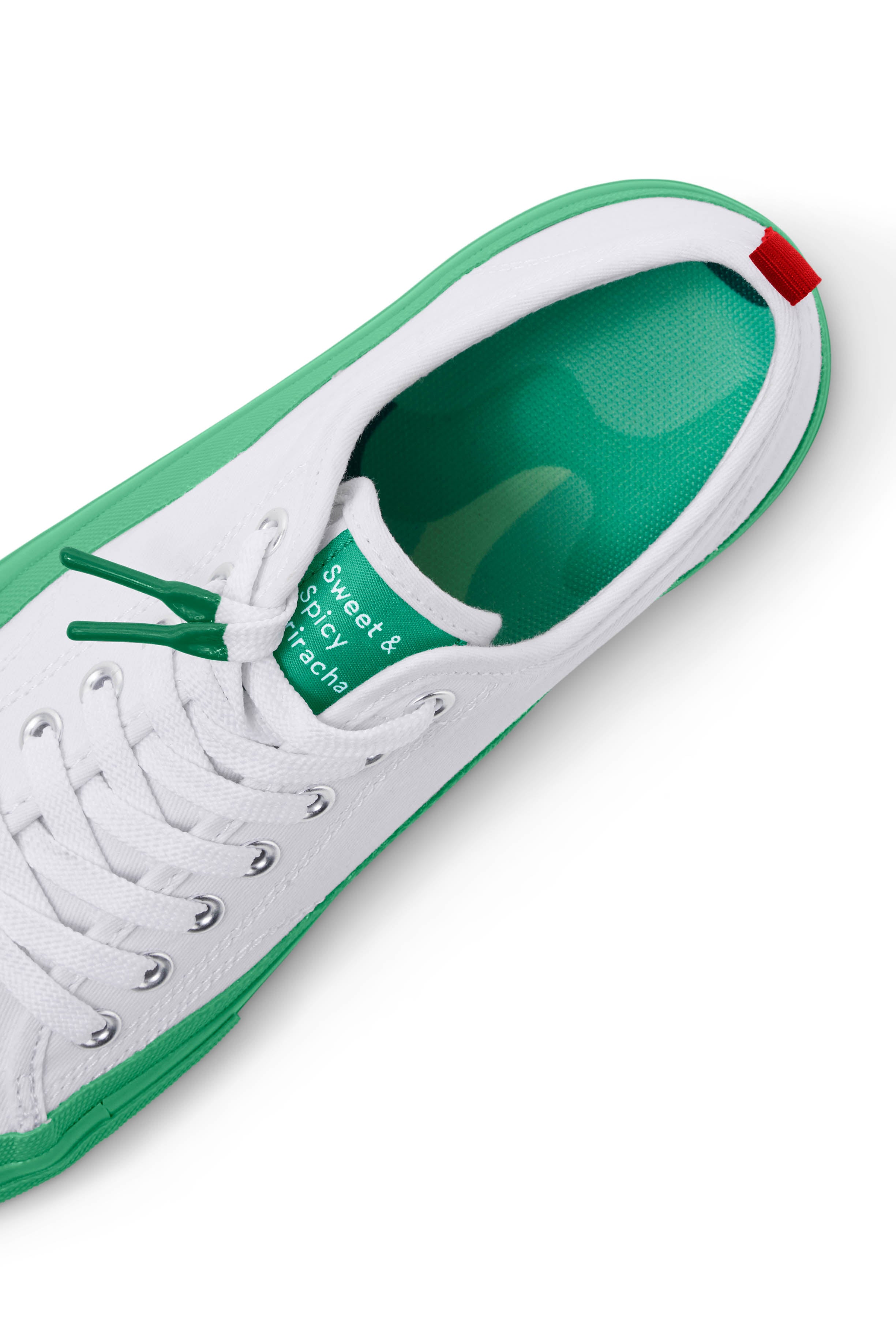 Top view of the drip patterned insole of the Dipped Kicks white shoes with green soles